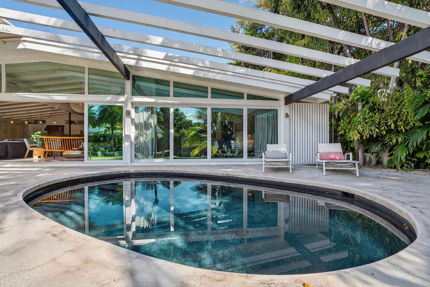 Kidney-shaped pool with exterior elevation and pergola