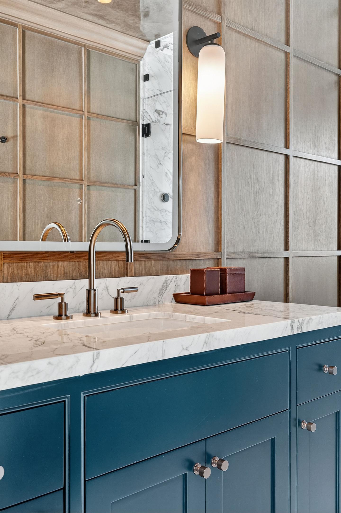 Primary bath vanity with marble and blue cabinetry