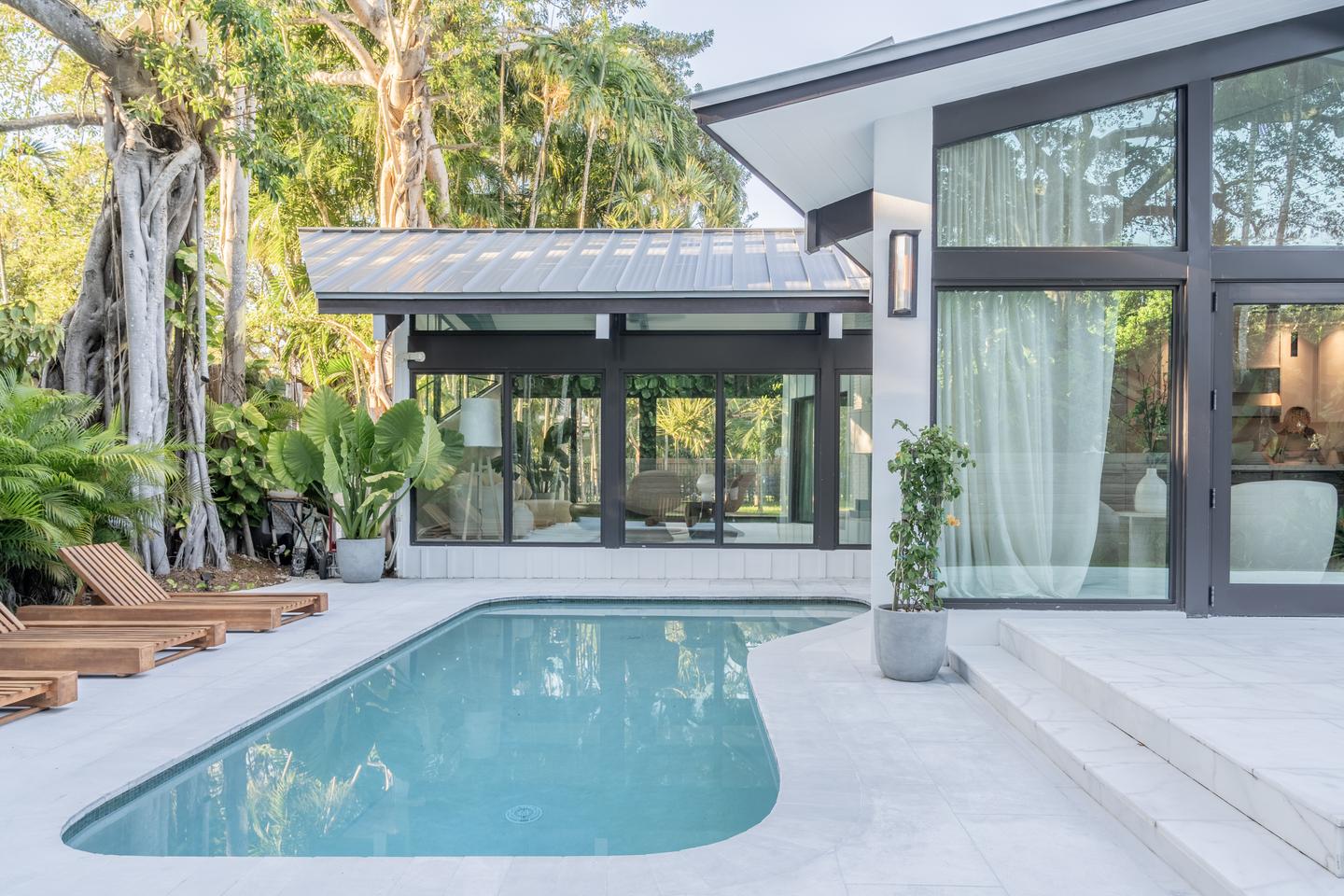 Pool with rear glass facade at dusk