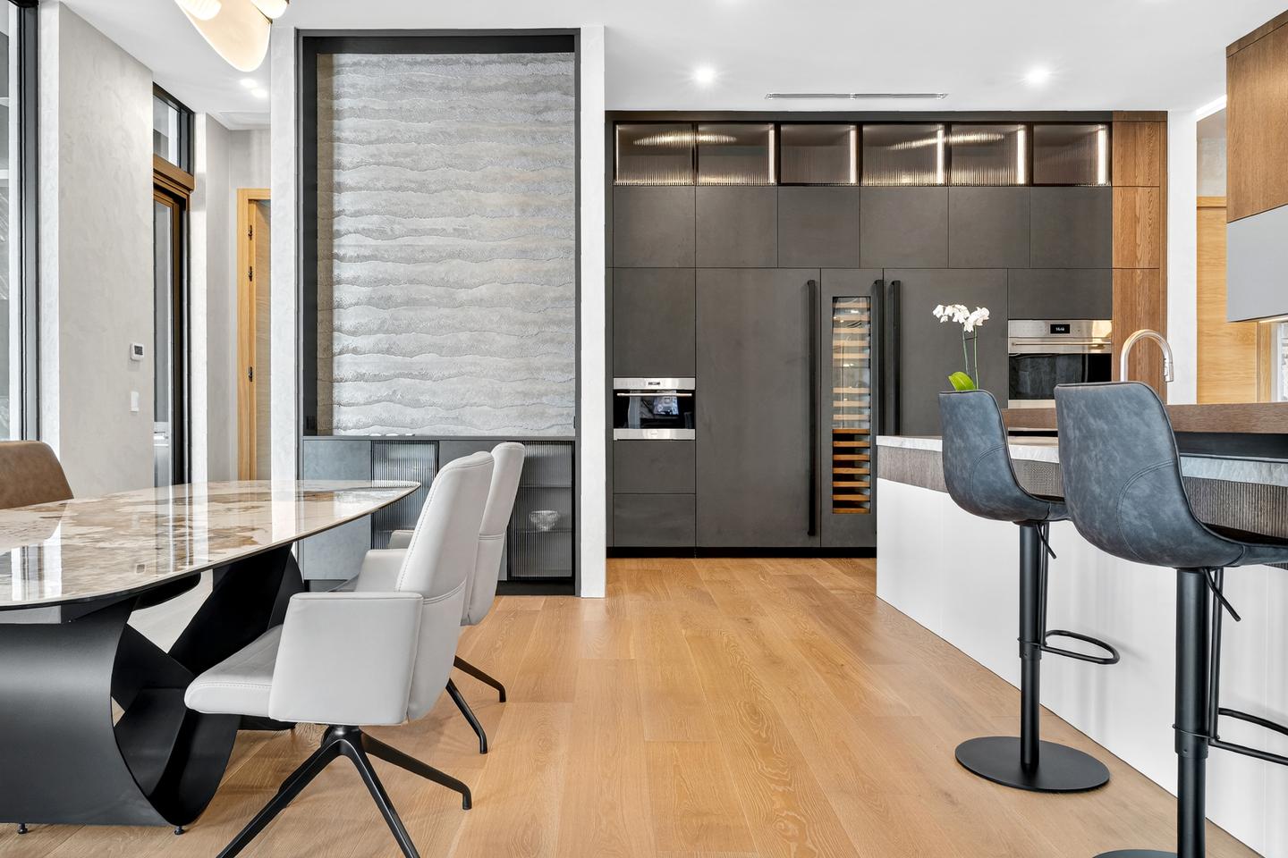 Kitchen and dining — dark cabinetry, marble dining table, island with bar stools
