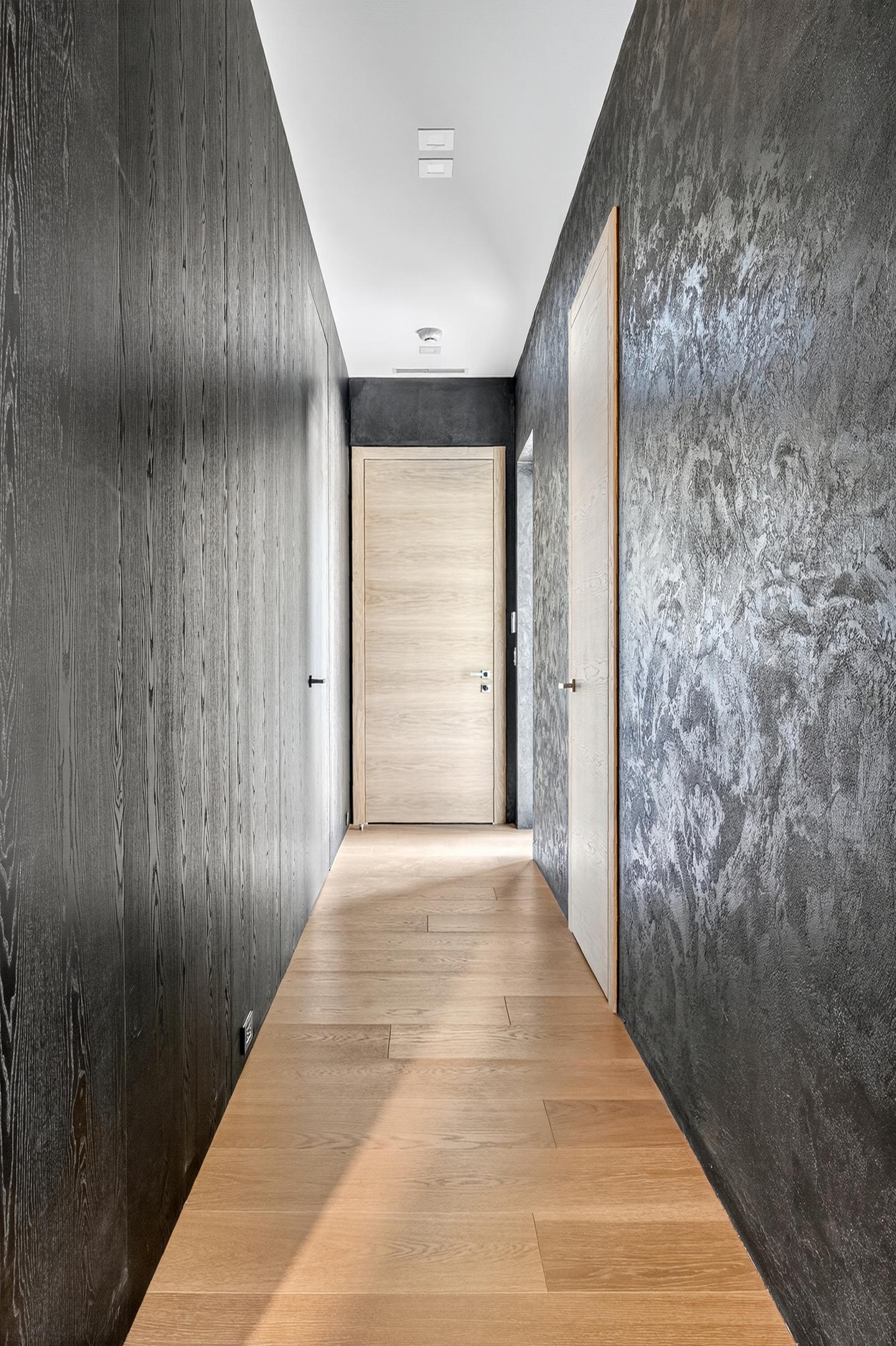 Hallway with ebonized wood walls and oak door