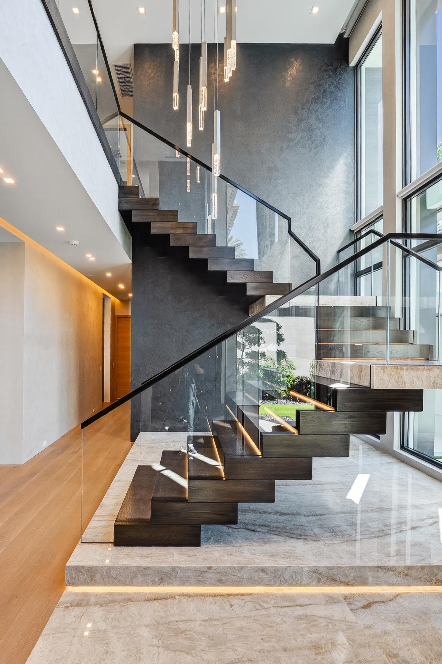 Grand stair with crystal pendants, marble landing, and double-height glass