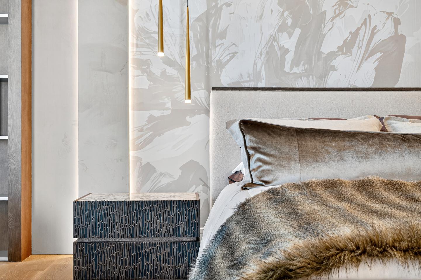Primary suite detail — abstract mural headboard and gold pendant