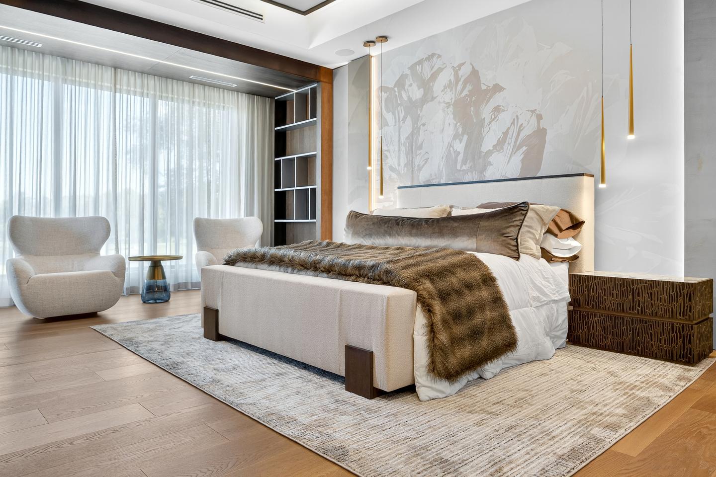 Primary suite — full room with fur throw, abstract mural headboard, and sitting area