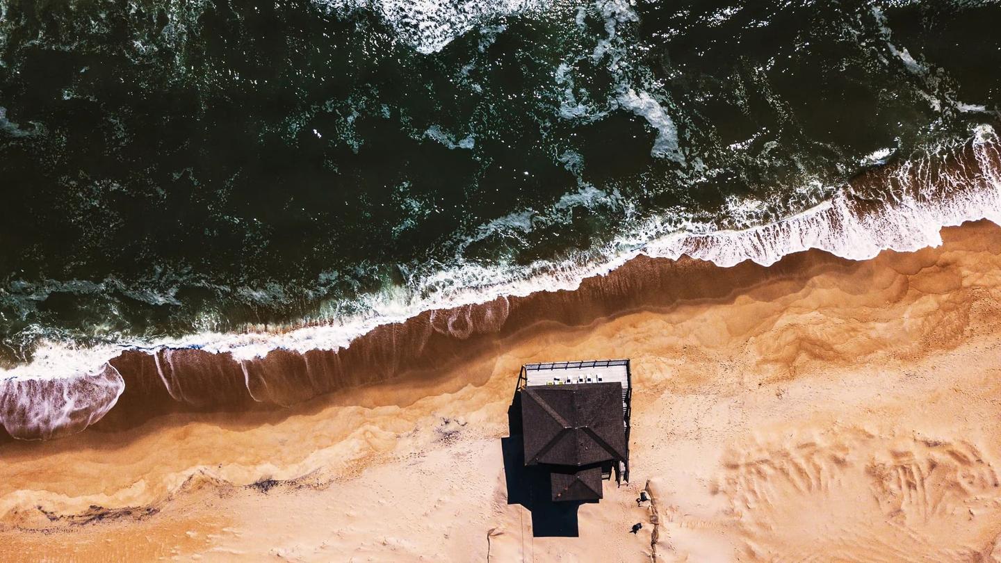 Aerial drone photograph of a luxury waterfront property showing the home, dock, and surrounding waterways