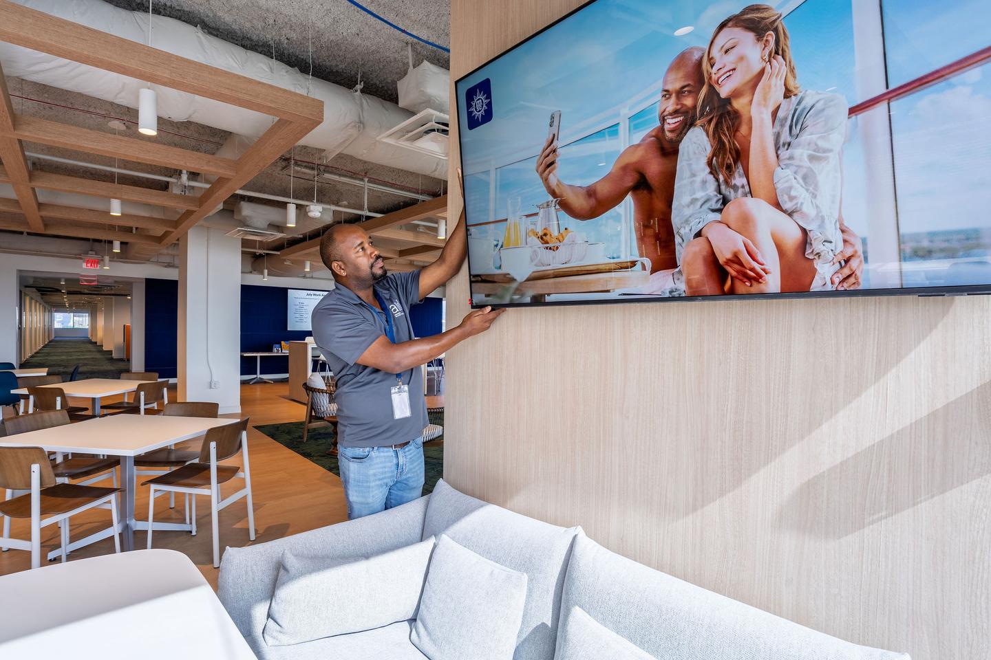 AV technician installing a wall-mounted display at MSC Cruises