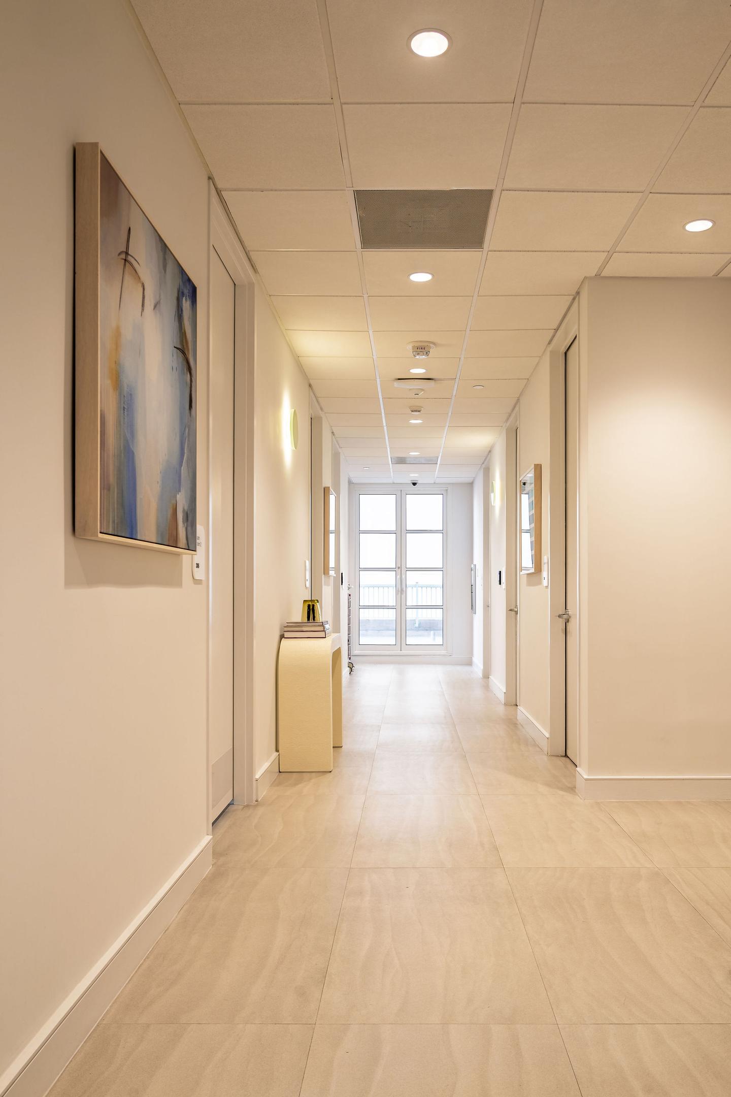 Long clinical corridor with curated artwork