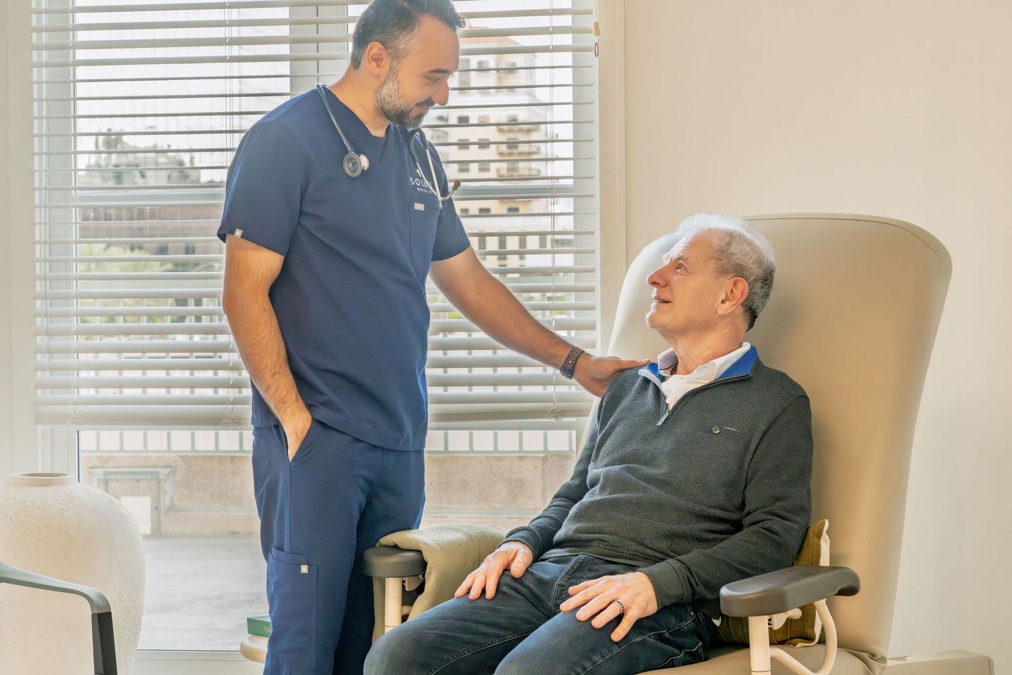 Physician speaking with seated patient