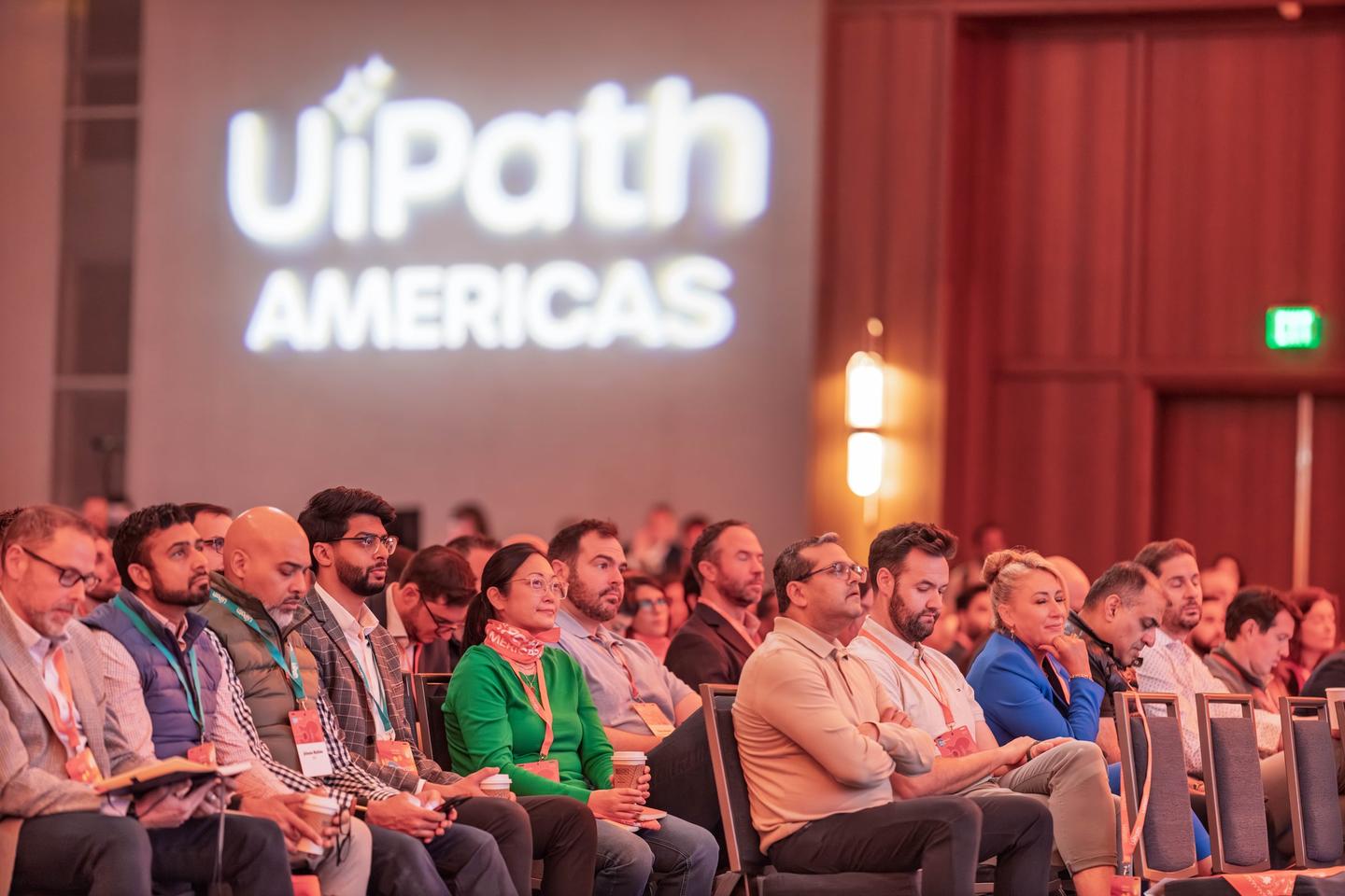 Corporate event keynote speaker on stage with professional lighting and engaged audience